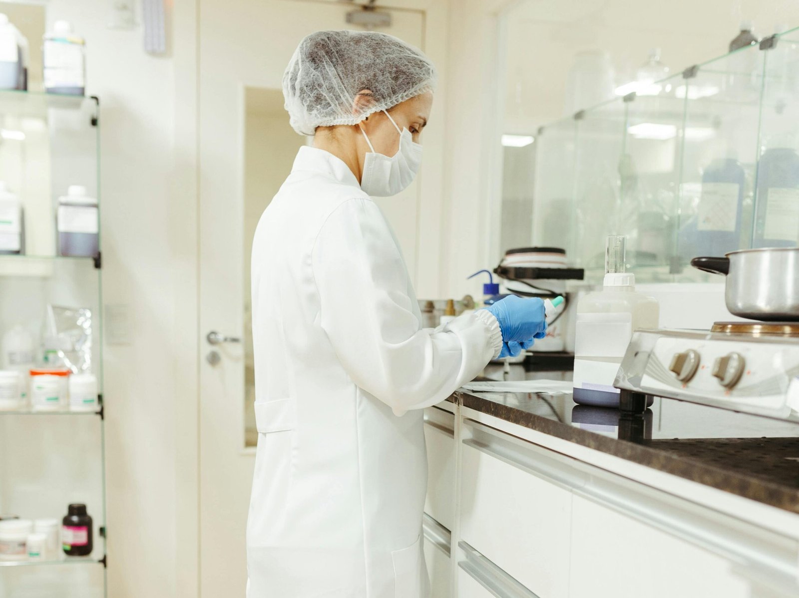 A female scientist in a lab coat performs a scientific experiment in a modern laboratory setting.
